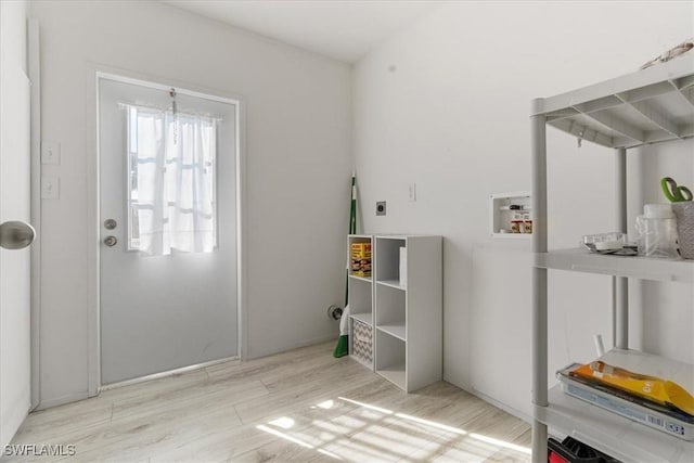 interior space featuring hookup for a washing machine, light hardwood / wood-style floors, and hookup for an electric dryer