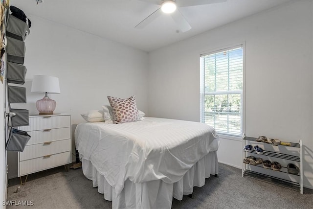 bedroom featuring multiple windows, ceiling fan, and dark carpet