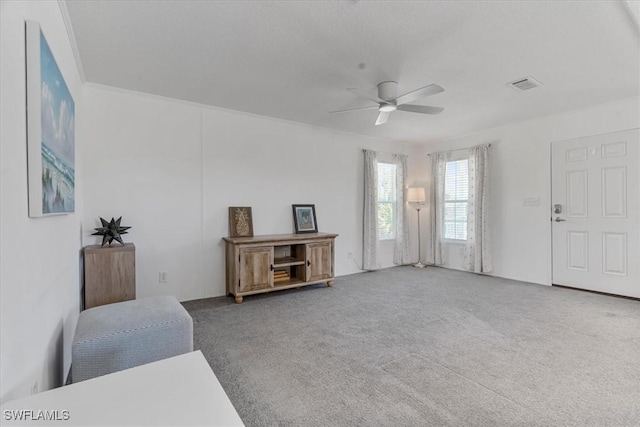 living area featuring carpet floors and ceiling fan