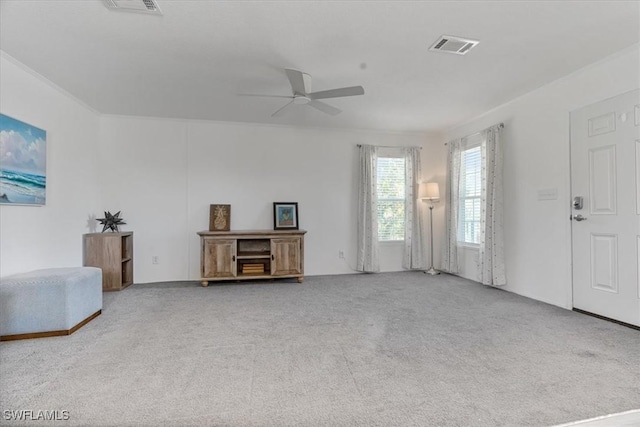 carpeted living room with ornamental molding and ceiling fan