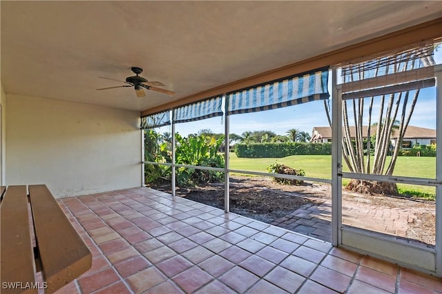 unfurnished sunroom featuring ceiling fan