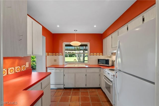 kitchen featuring sink, white appliances, decorative backsplash, decorative light fixtures, and tile patterned floors