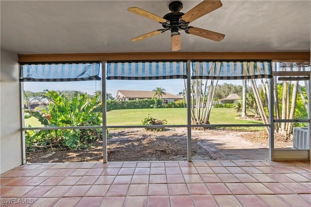 unfurnished sunroom with ceiling fan