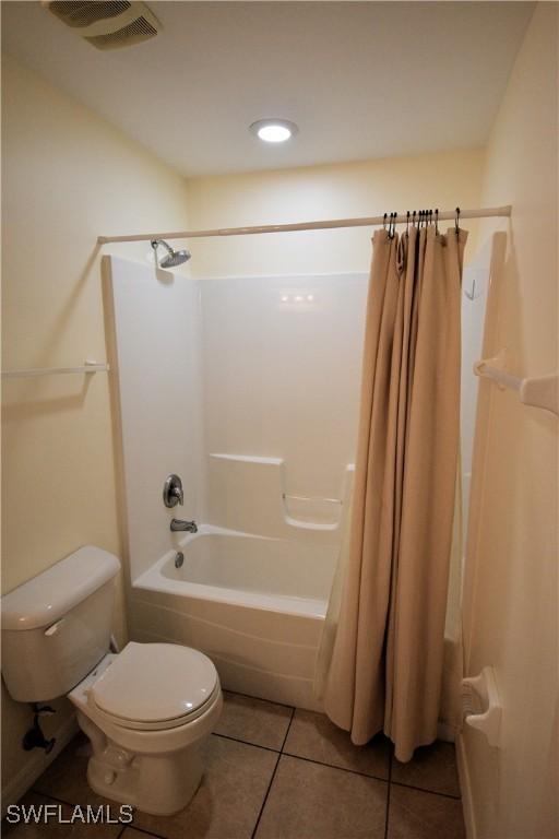 bathroom featuring tile patterned flooring, toilet, and shower / bath combo with shower curtain