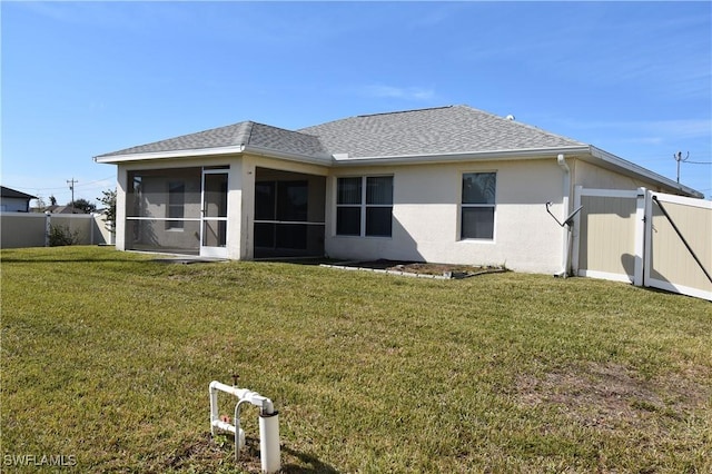 back of property with a yard and a sunroom