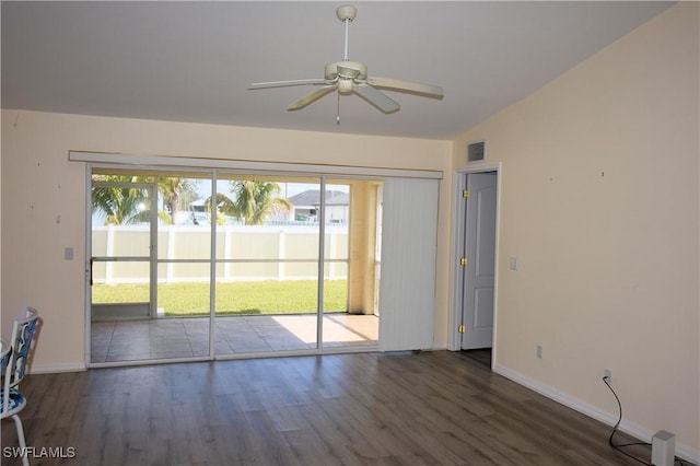 spare room featuring dark wood-type flooring, ceiling fan, and vaulted ceiling