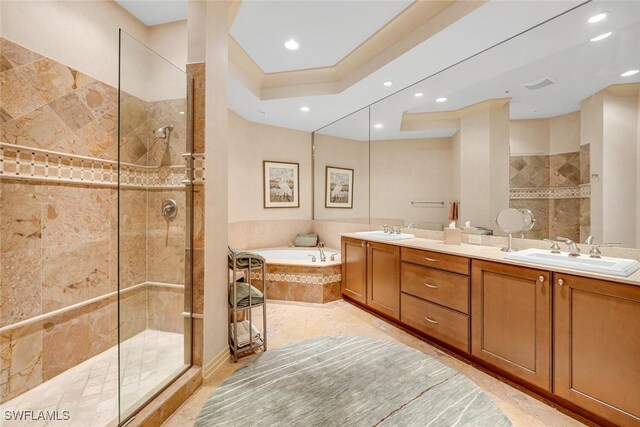 bathroom with vanity and shower with separate bathtub