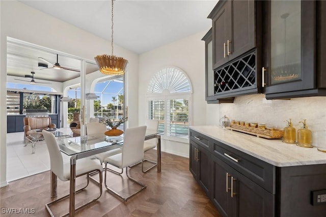 dining room featuring dark parquet flooring, a wealth of natural light, and ceiling fan