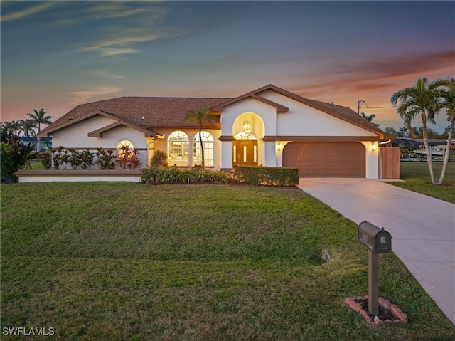 view of front of property featuring a garage and a yard