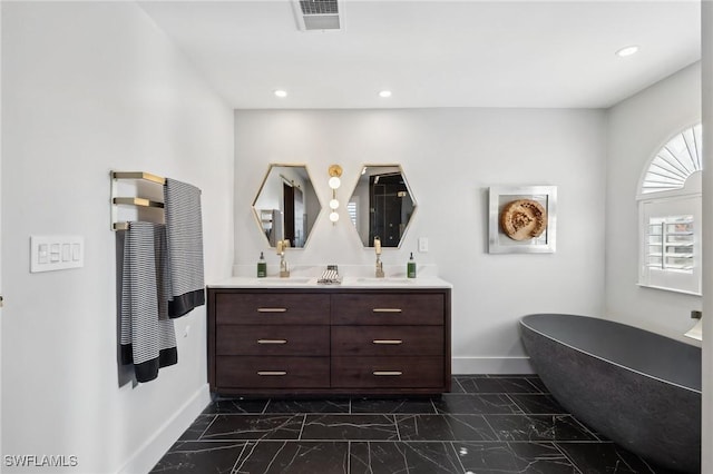 bathroom with a washtub and vanity