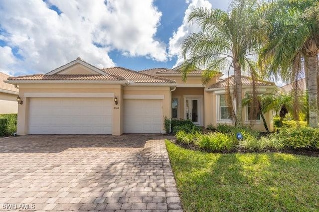 mediterranean / spanish house featuring a garage and a front yard