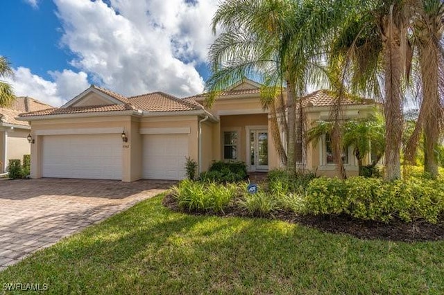 mediterranean / spanish-style home with a garage and a front yard