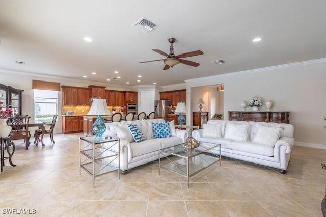 tiled living room with crown molding and ceiling fan