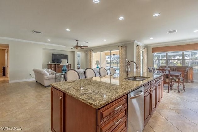 kitchen featuring dishwasher, sink, a kitchen island with sink, crown molding, and light stone countertops