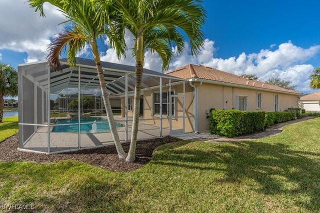 rear view of house with a lanai, a patio area, and a lawn