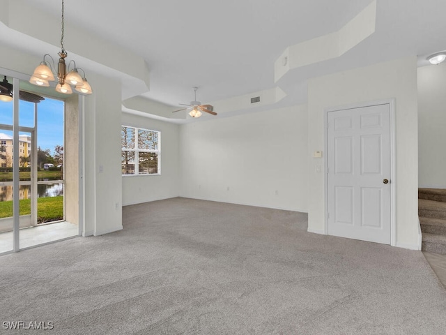 carpeted empty room with ceiling fan with notable chandelier