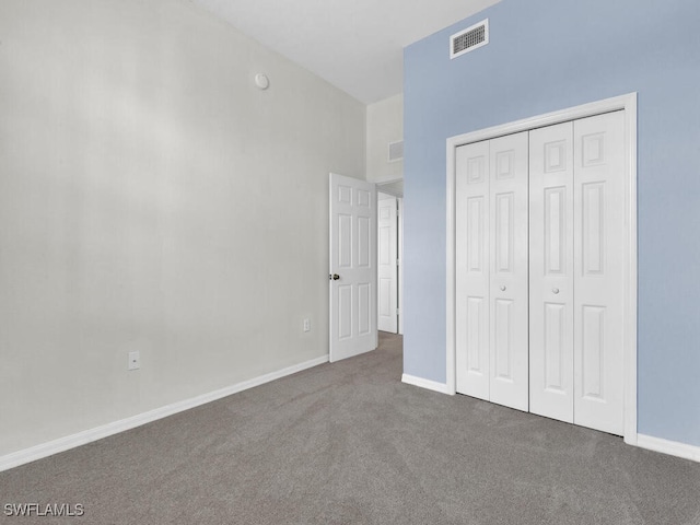 unfurnished bedroom with a closet and dark colored carpet