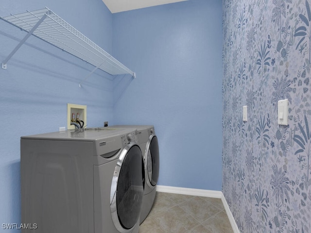 clothes washing area featuring light tile patterned floors and washing machine and clothes dryer