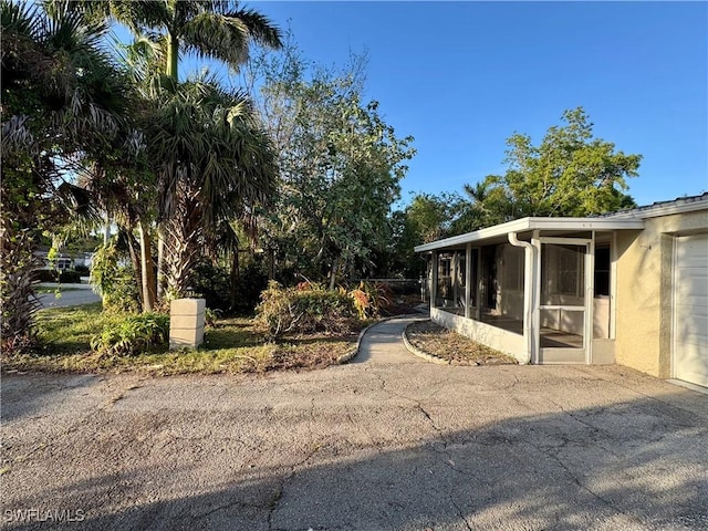 view of property exterior with a sunroom and stucco siding