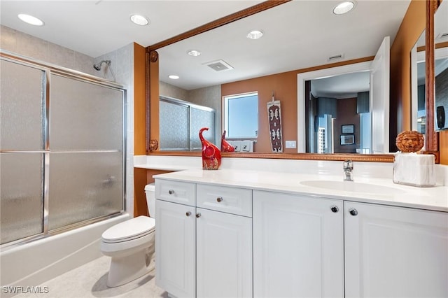 full bathroom featuring tile patterned flooring, vanity, shower / bath combination with glass door, and toilet