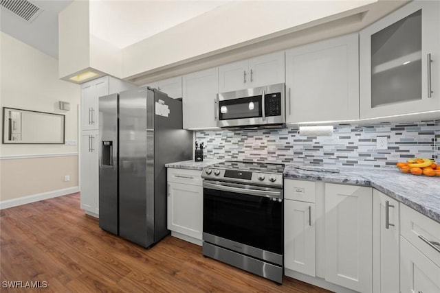 kitchen featuring light stone counters, decorative backsplash, white cabinets, and appliances with stainless steel finishes