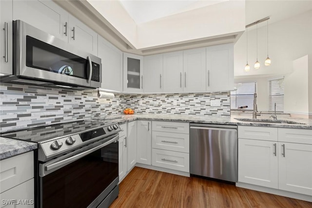 kitchen with sink, decorative light fixtures, white cabinets, and appliances with stainless steel finishes