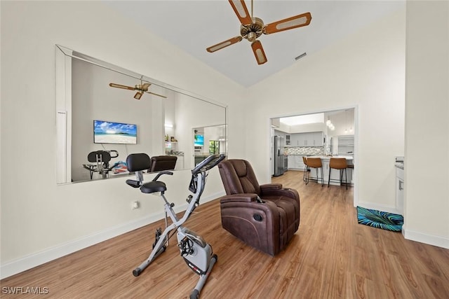 workout area with ceiling fan, lofted ceiling, and light hardwood / wood-style floors