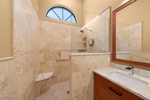 bathroom featuring vanity, a tile shower, and tile walls