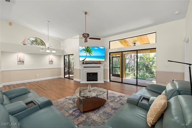 living room featuring wood-type flooring, ceiling fan, and vaulted ceiling