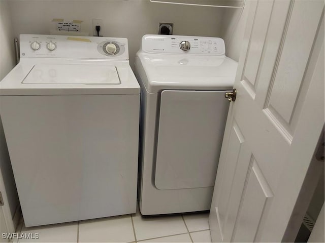 clothes washing area featuring light tile patterned floors and independent washer and dryer