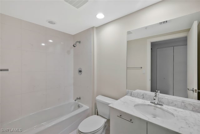 full bathroom with vanity, tiled shower / bath combo, and toilet