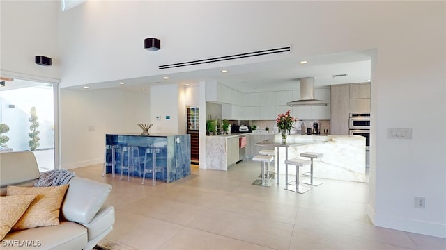 living room with light tile patterned flooring and a high ceiling