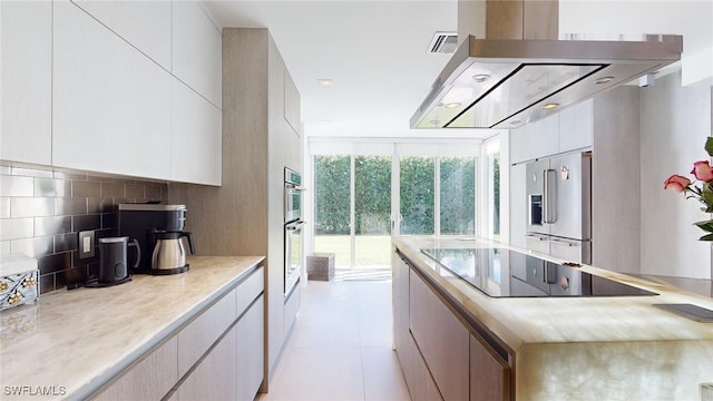 kitchen featuring tasteful backsplash, light tile patterned floors, white cabinetry, and appliances with stainless steel finishes