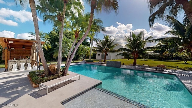 view of swimming pool featuring a patio and an outdoor bar