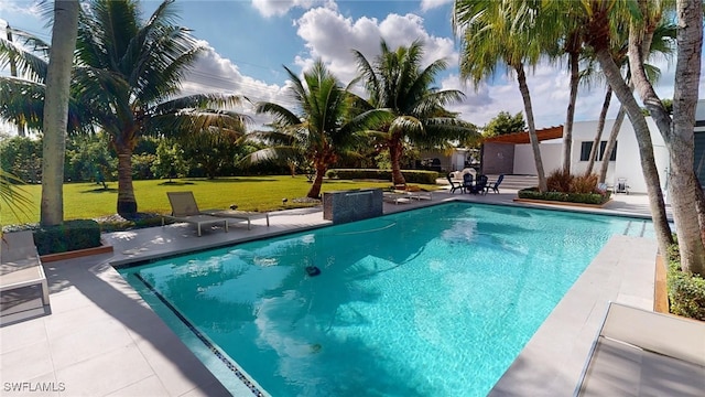 view of swimming pool with a yard and a patio