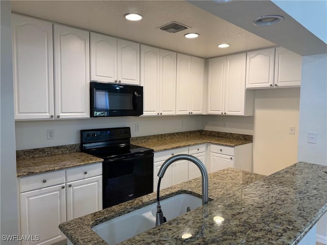 kitchen with sink, black appliances, dark stone counters, and white cabinets