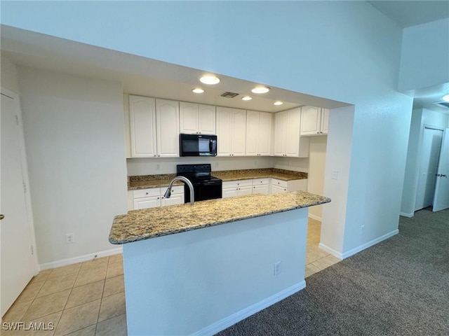 kitchen with white cabinetry, stone countertops, a center island, light tile patterned floors, and black appliances