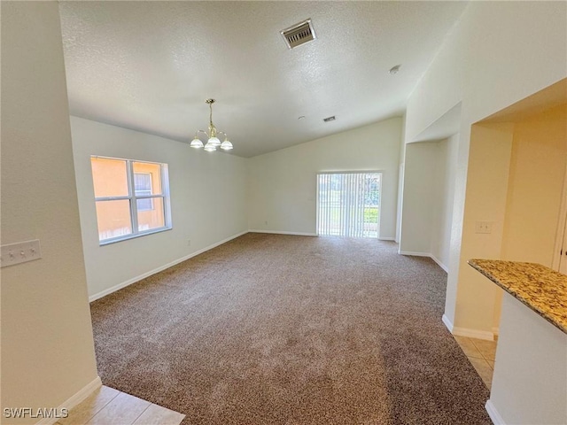 carpeted spare room featuring lofted ceiling, a notable chandelier, and a textured ceiling