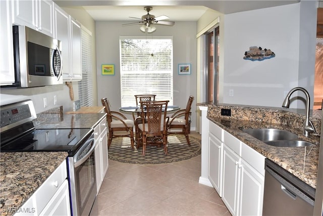 kitchen with white cabinetry, sink, stainless steel appliances, and dark stone counters