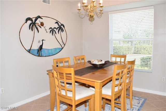 dining area with tile patterned flooring and a notable chandelier