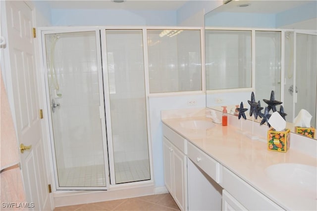 bathroom featuring tile patterned flooring, vanity, and a shower with door