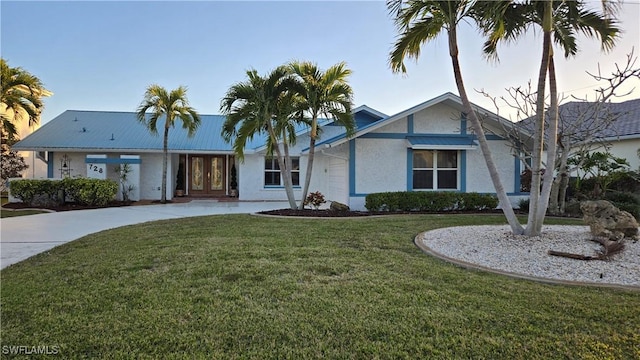 view of front of home featuring a front lawn and french doors