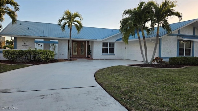 view of front of home featuring a garage and a lawn