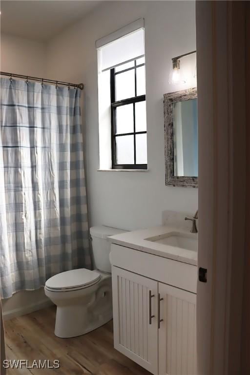 full bathroom featuring vanity, wood-type flooring, shower / bath combo, and toilet