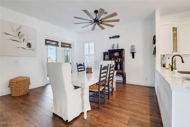 dining area featuring dark hardwood / wood-style flooring, sink, and ceiling fan