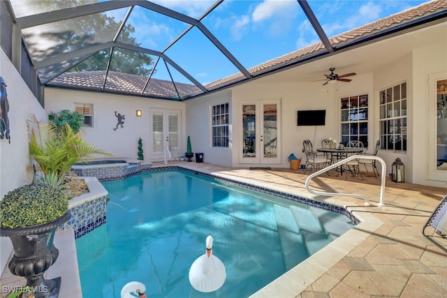 view of pool with french doors, a lanai, an in ground hot tub, ceiling fan, and a patio