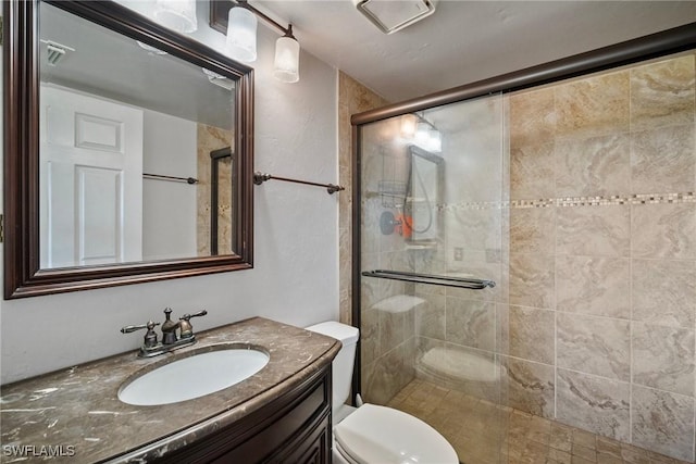 bathroom featuring vanity, toilet, and a shower with door