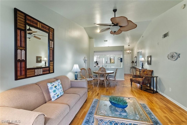 living room featuring ceiling fan with notable chandelier, hardwood / wood-style floors, and high vaulted ceiling