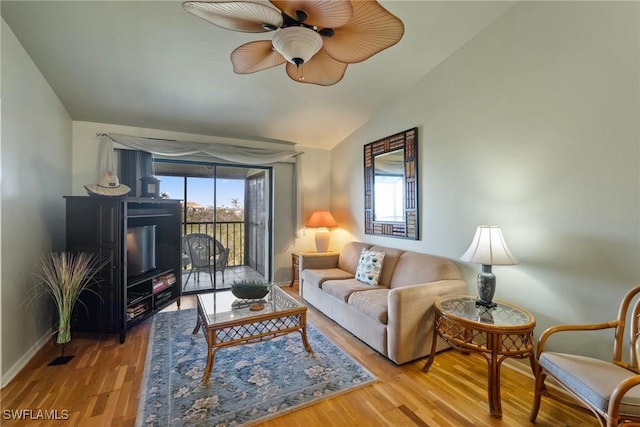 living room featuring vaulted ceiling, light hardwood / wood-style floors, and ceiling fan