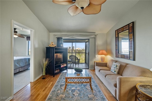 living room featuring lofted ceiling, ceiling fan, and light wood-type flooring